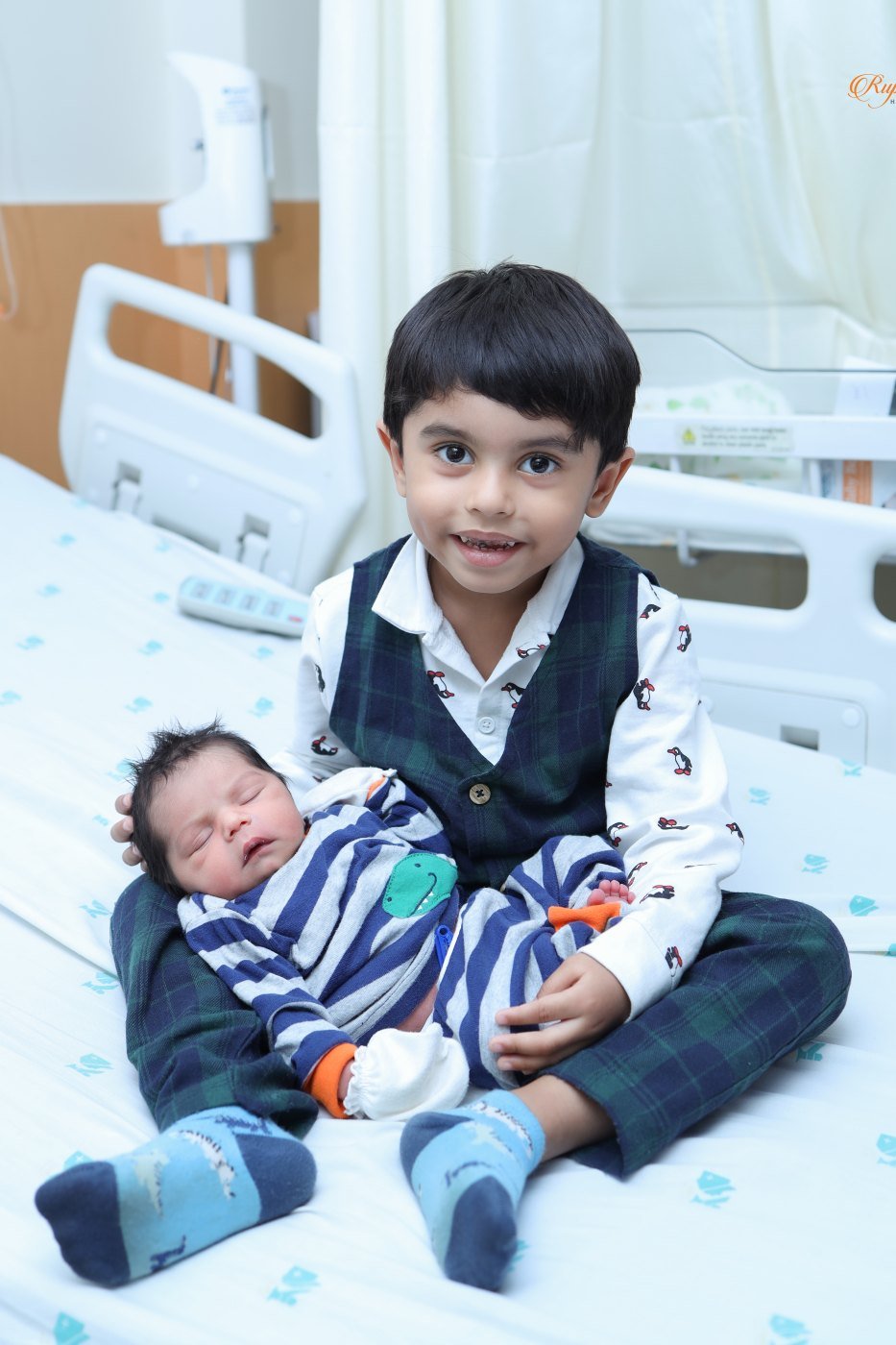 Older sibling meeting the newborn on a hospital bed